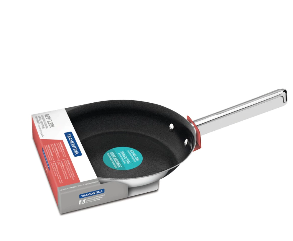 Frigideira Tramontina Ventura Inox Antiaderente preta de 24cm em uso, com ovos mexidos sendo preparados e utensílios de silicone ao lado, destacando sua superfície antiaderente.