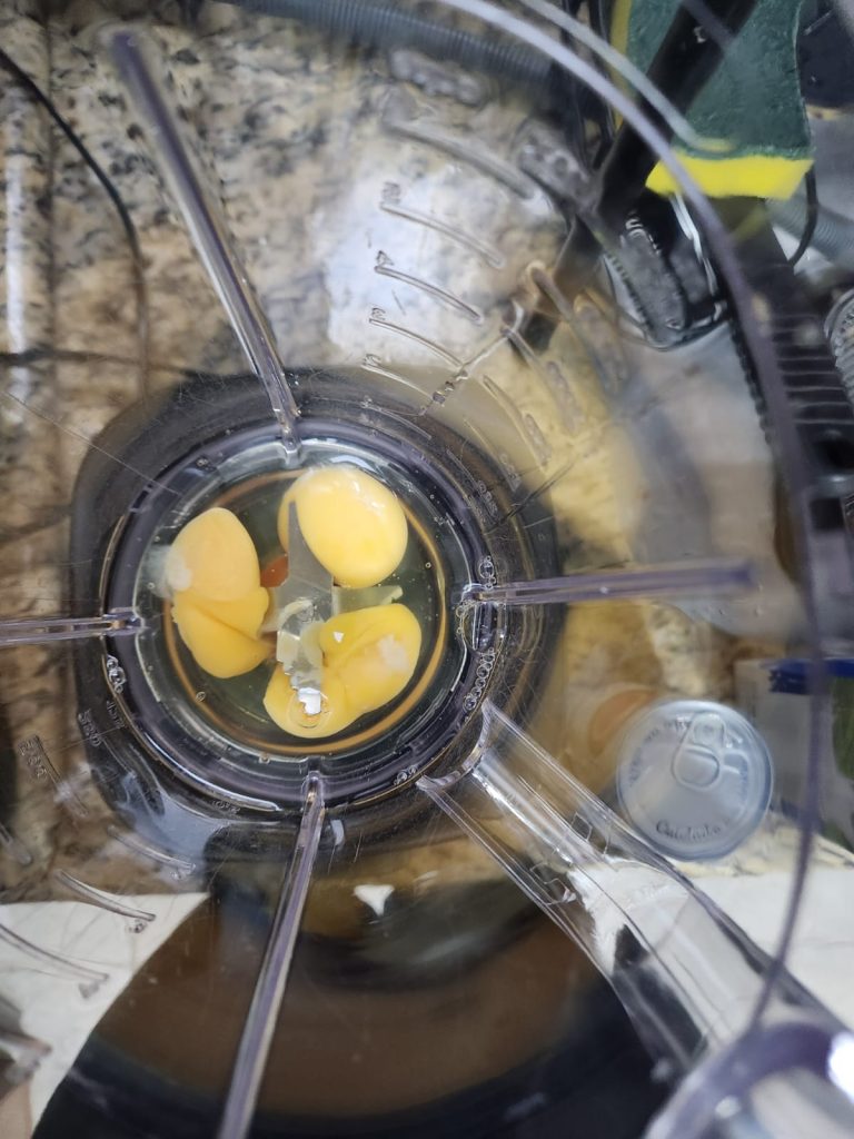 Três ovos inteiros sendo batidos sozinhos no liquidificador antes de acrescentar o leite condensado, truque para eliminar o cheiro forte de ovo no pudim