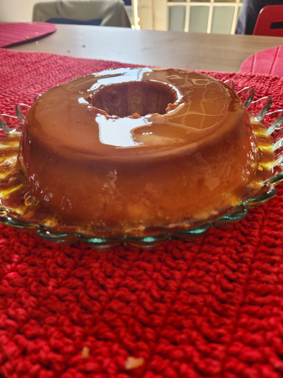 Pudim de leite condensado pronto servido no prato com calda de caramelo escorrendo pelas laterais